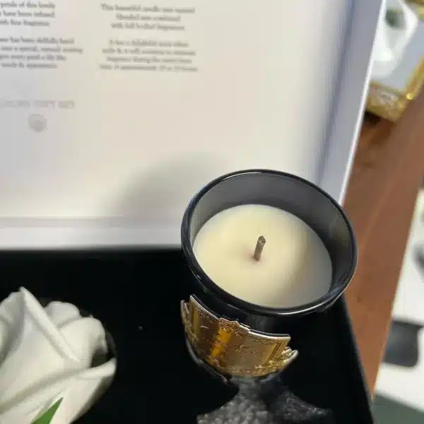 Vela perfumada Côte Noire em recipiente preto com base dourada, dentro da caixa de apresentação.