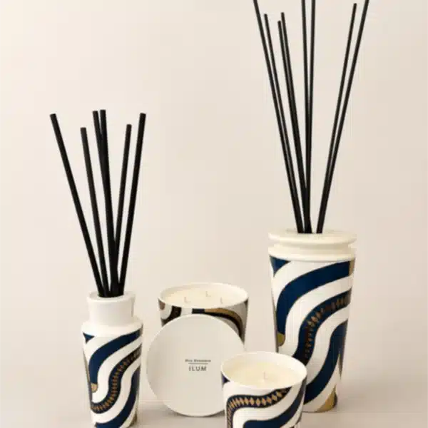 Difusor de aromas e velas em cerâmica branca com padrão geométrico azul e dourado, da coleção Ilum.